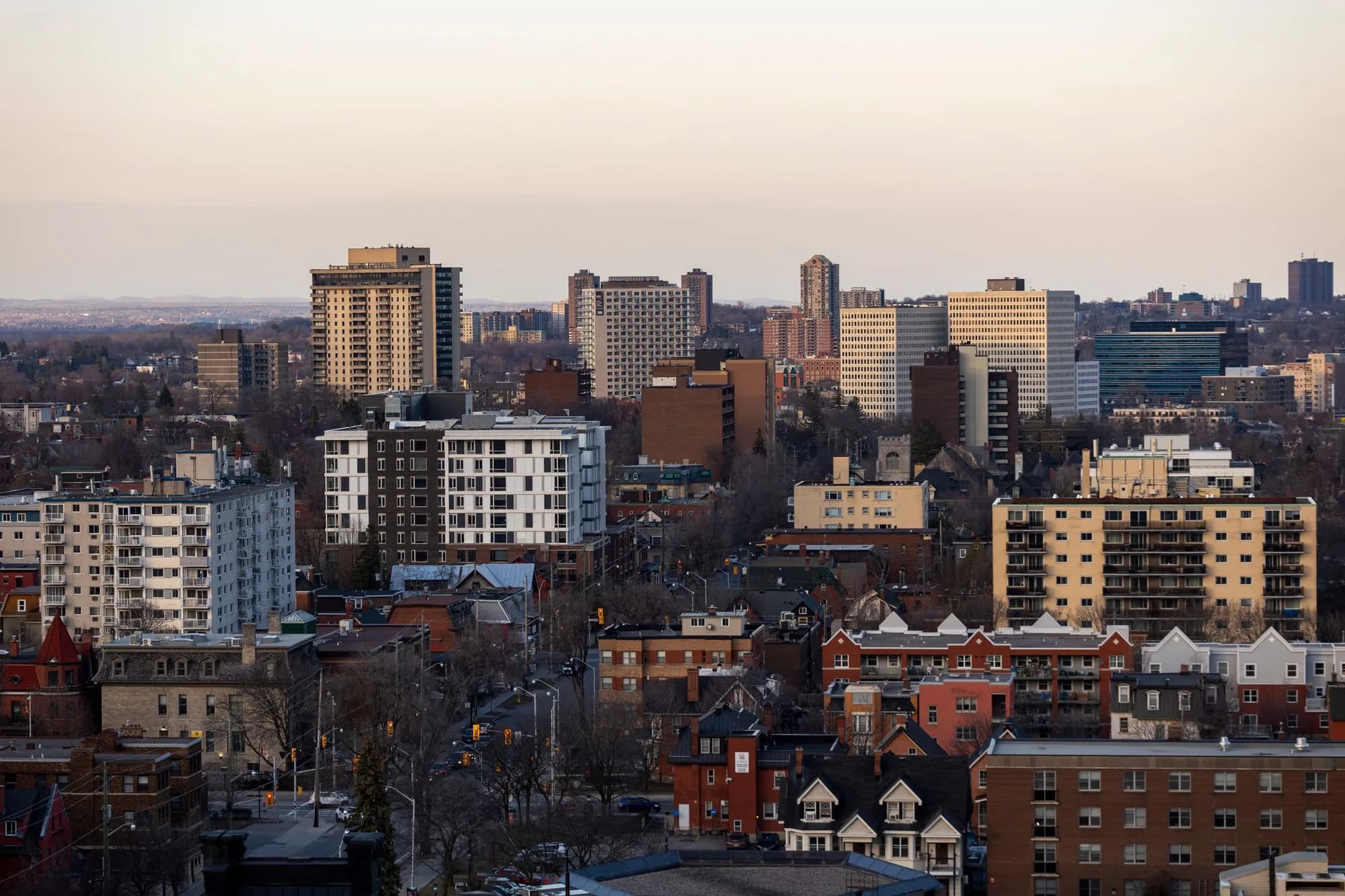 Aerial view across downtown Ottawa as city lights appear at dusk.