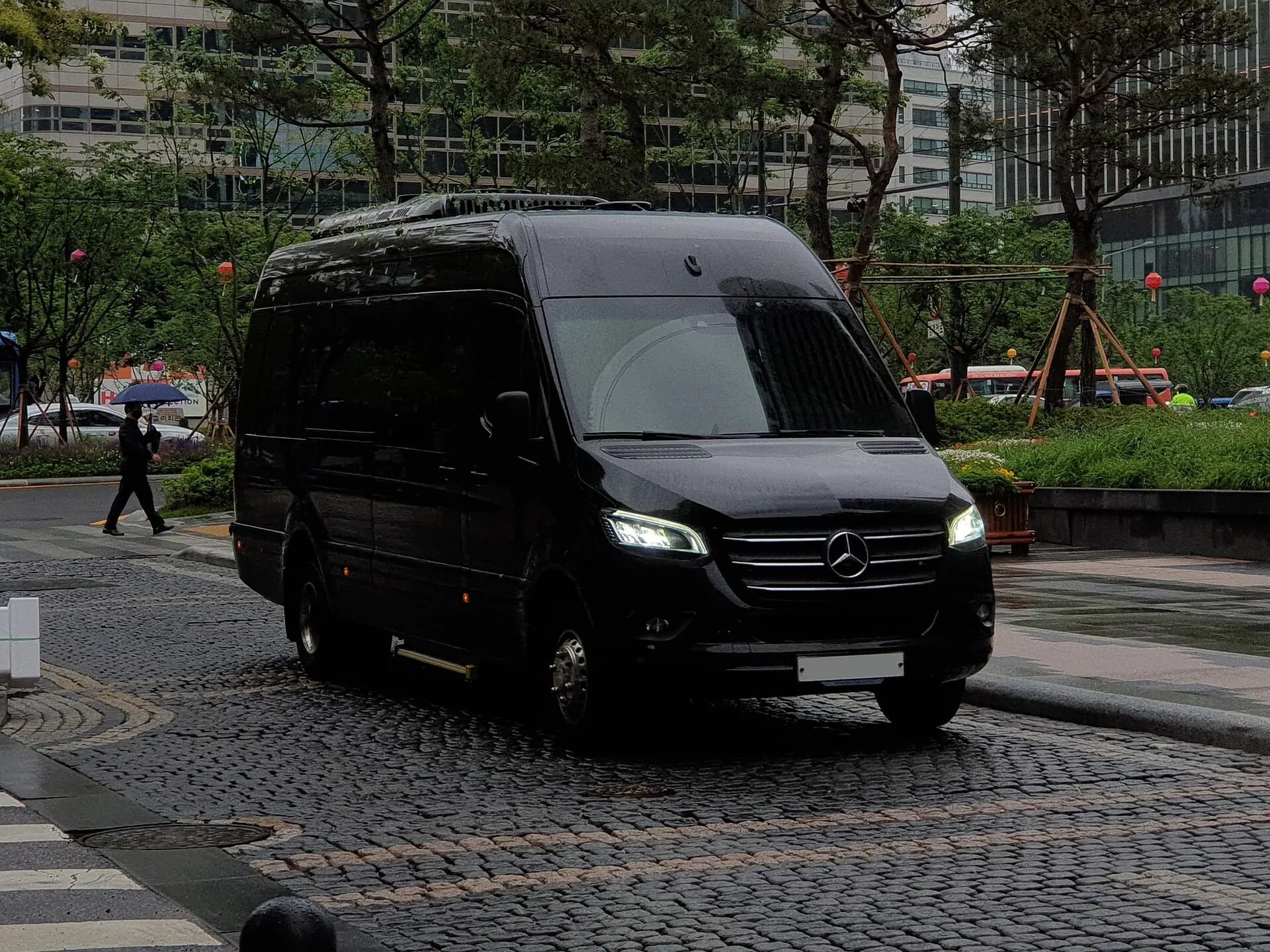 Black Mercedes-Benz high-roof Passenger Sprinter with passenger windows.